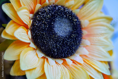 Bright artificial sunflower bloom showcasing its detailed petals and center in vibrant yellow and dark brown color