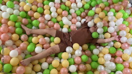Little Girl Toddler Playing in Colorful Ball Pool in Children Playroom playground