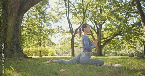 Wallpaper Mural young beautiful white girl doing yoga in park among trees in clearing on summer day Torontodigital.ca