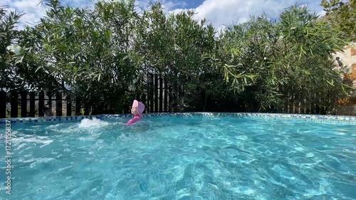 Little toddler girl child Swimming in outdoor Pool on Sunny Day in Summer childhood