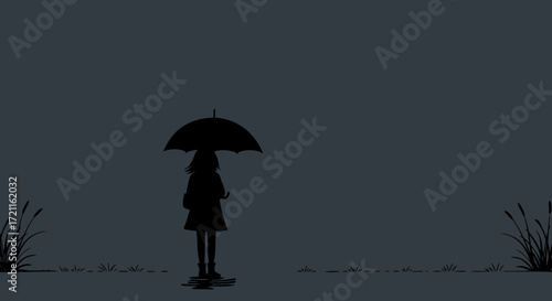 Solitary figure under an umbrella braving a dark and rainy evening street scene