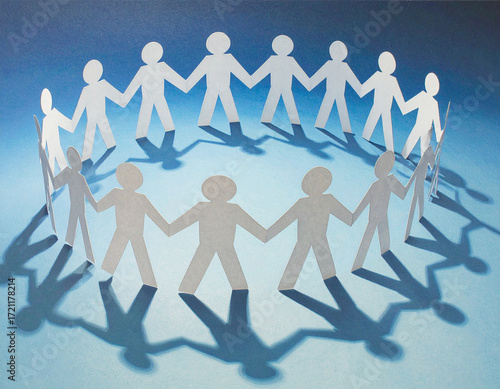 A circle of paper doll figures holding hands in a chain symbolizes unity, teamwork, and community support against a blue backdrop