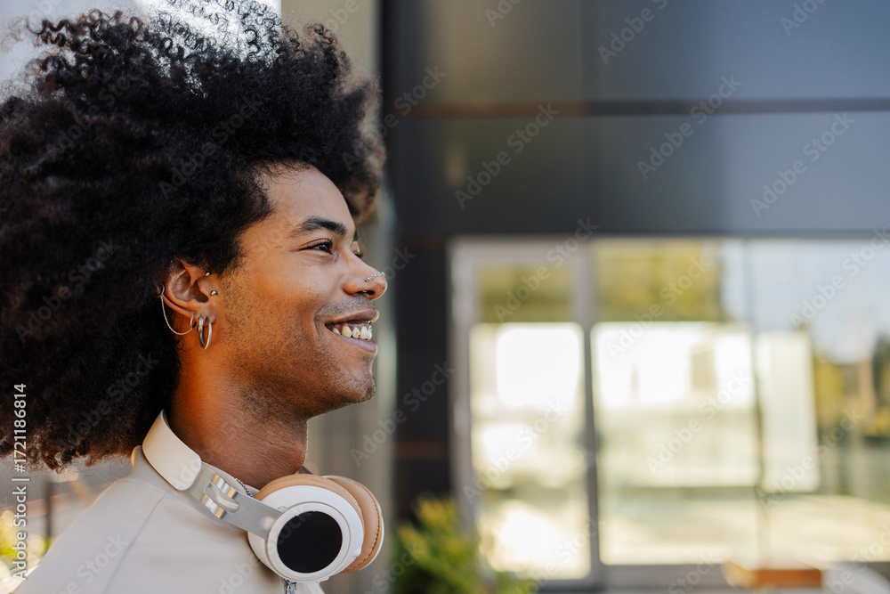 © Westend61 - Happy young man with curly hair and wireless headphones © Westend61 - Happy young man with curly hair and wireless headphones