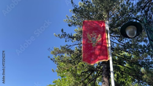 National flag of the independent state of Montenegro on the Balkan Peninsula on background of blue sky