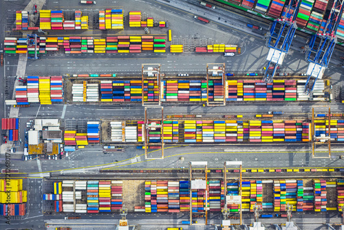 Aerial view of vibrant, stacked shipping containers create a colorful mosaic across the port, a testament to global trade and logistics, Port of La Spezia, Liguria, Italy.