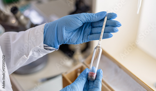 Photos A female chemist takes a hydrometer to subsequently measure the density of a liq