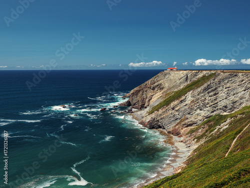 Ocean landscape with a lighthouse in the distance on a summer day