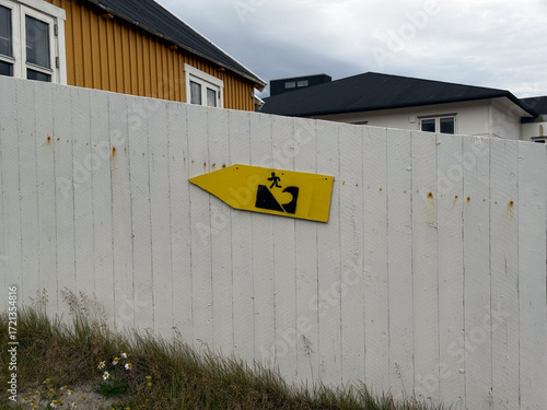 A Tsunami Evacuation Route sign posted at a fence in Uummannaq, Greenland