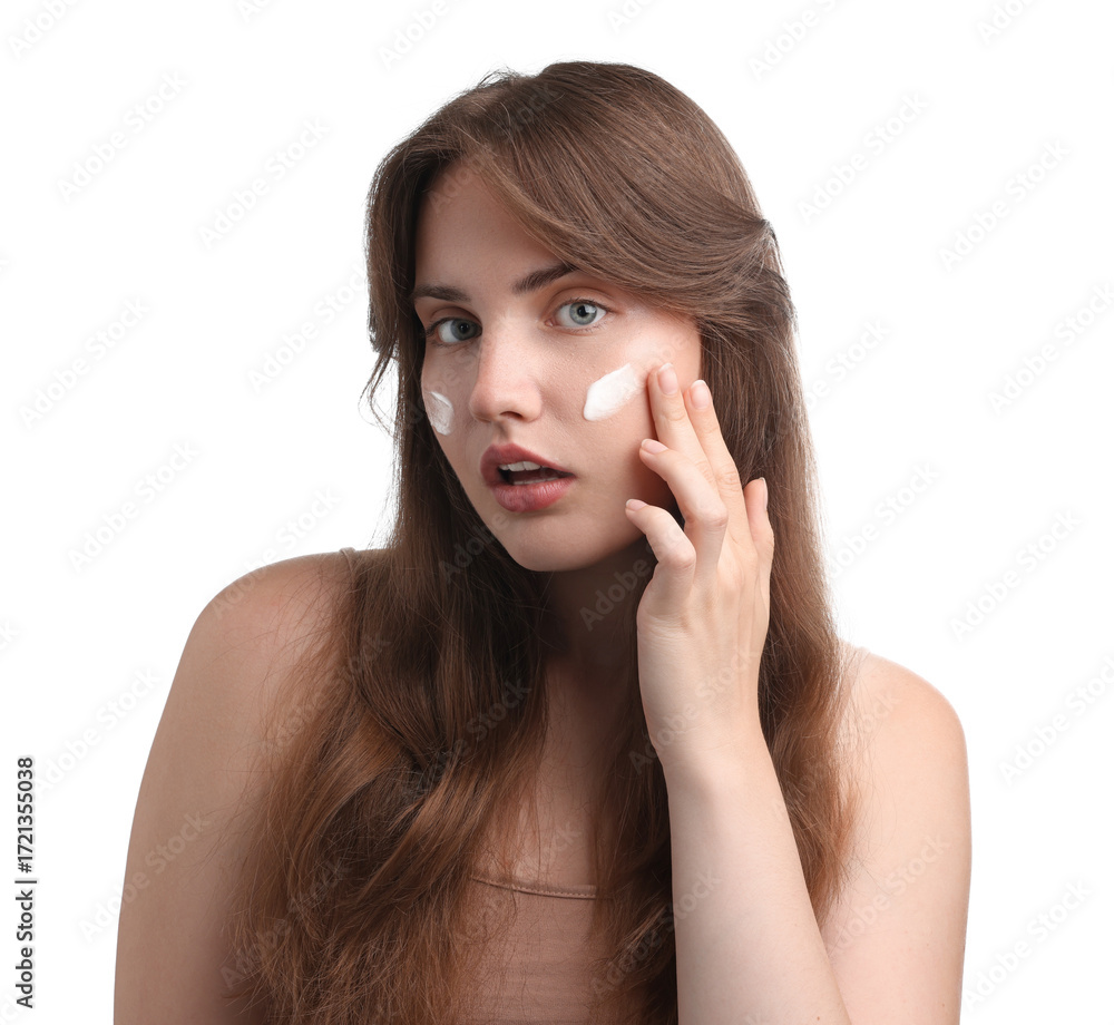 Fototapeta premium Beautiful woman applying cream onto her face on white background