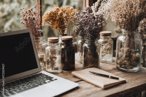 Rustic Workstation with Dried Flowers, Laptop, and Notebook on Wooden Desk.