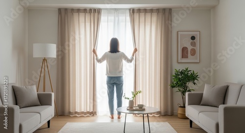 Woman opening curtains in modern living room  