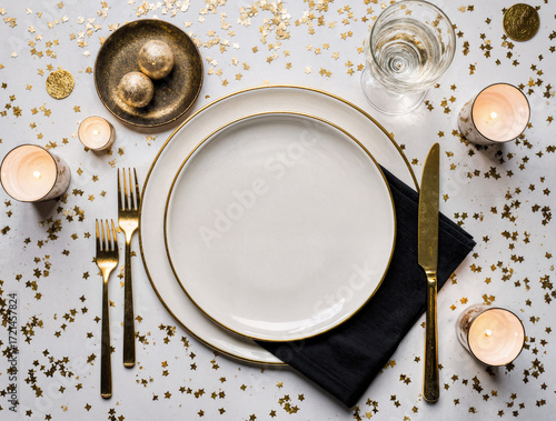 Elegant Single New Year’s Eve Dinner Setting with Gold Cutlery, Black Napkin, and Festive Champagne Glass