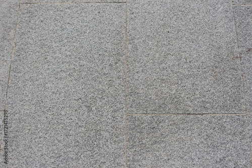 Gray granite paving slabs on a city street, background.