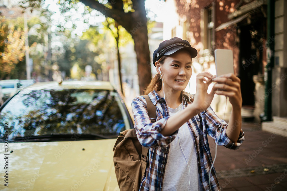 Fototapeta premium Young woman taking a selfie outdoors
