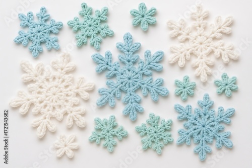 Crocheted snowflakes in blue, white, and mint green arranged on a light background for winter crafting inspiration