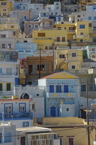 Densely built-up Mediterranean town of Menetes with pastel-coloured houses under a sunny sky, Menetes, Karpathos, Greece