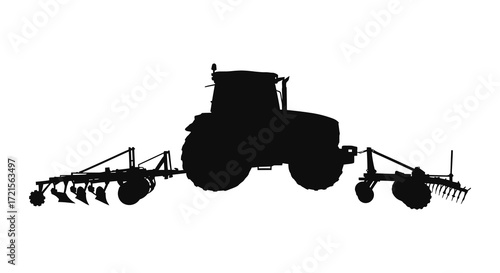 A silhouette of a modern tractor with cultivation equipment attached