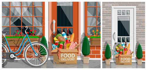 Food delivery box with grocery set standing near door. Shopping at home concept. Fast and free delivery.