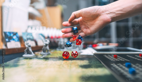 Man hand dice roll d20 for critical hit attack role playing tabletop game and board game hobby