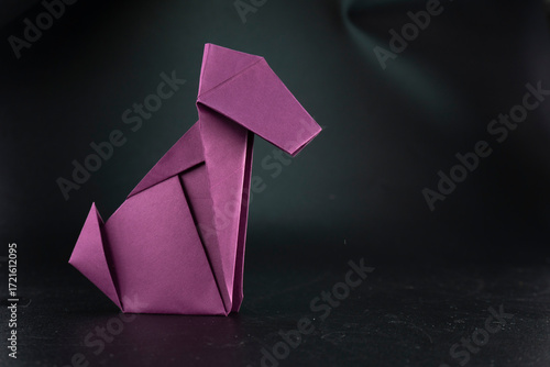 Paper dog on a black background. Origami dog. Animal. Paper crafts.