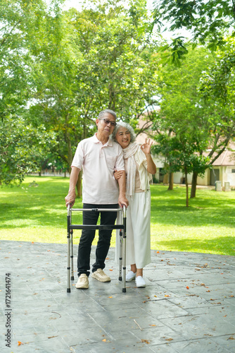 Happy Asian Senior Couple Relaxing Together in Park with Wheelchair