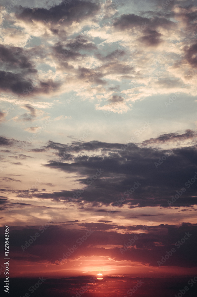 Naklejka premium A breathtaking sunset fills the sky with a vibrant display of red, purple, and orange hues