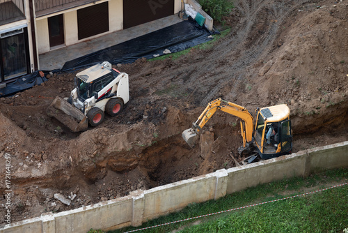 Excavator and loader working on residential construction site digging soil