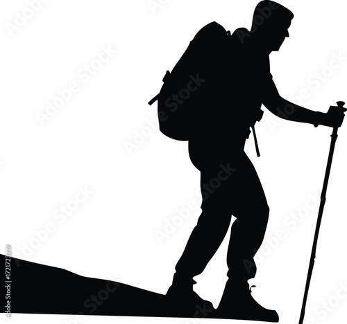Silhouette of a hiker with a backpack and trekking pole walking on a mountain path