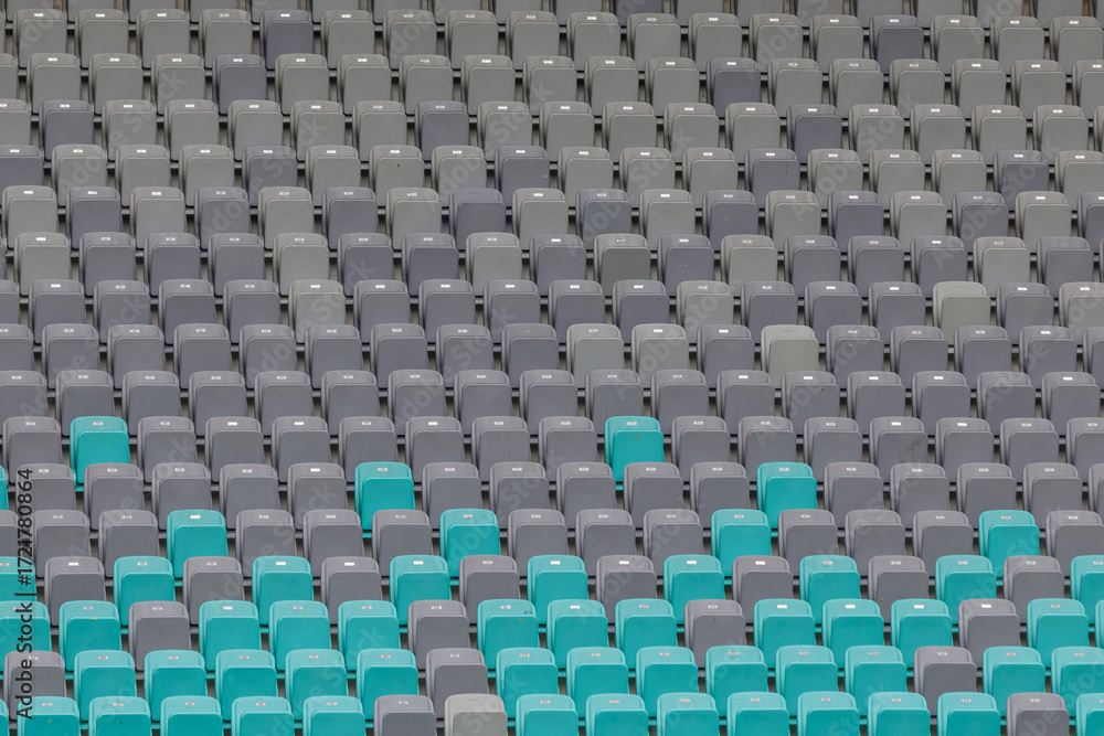 Naklejka premium Rows of seats in a football stadium showcase a mix of green and gray colors, creating a vibrant visual before the match.