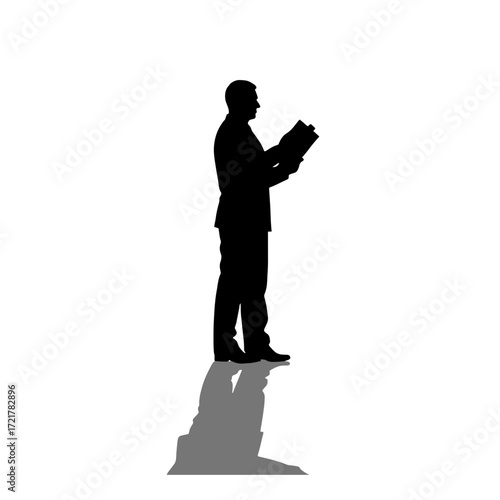 Businessman reading document while standing in silhouette  