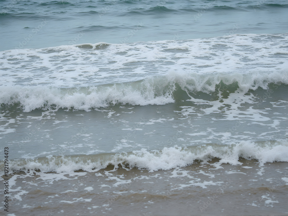 Fototapeta premium Waves Crashing Gently on Sandy Beach Shoreline