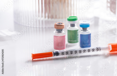Close up of Vials with Various Injectable Peptides Next to Syringes