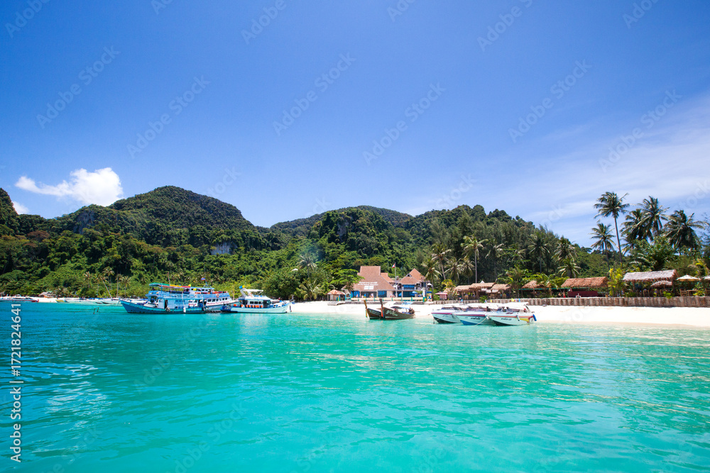Obraz premium Boat and Jet Ski on Beach Shoreline with Mountain Ocean Panorama