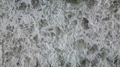 Waves crash and dissolve along the shore of central California in this overhead drone shot in 4k. 