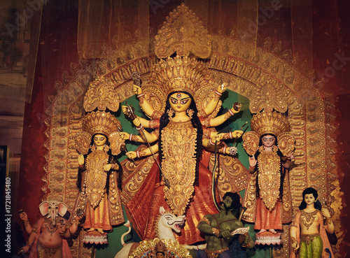Family of hindu Goddess Durga fighting demon Mahishasura, along with Laxmi, Saraswati, Kartikeya and Ganesha. Photographed inside a pandal during Durga puja festival in Kolkata.