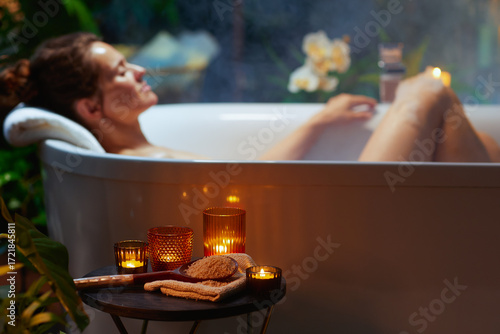 Woman Relaxing in Candlelit Bathtub