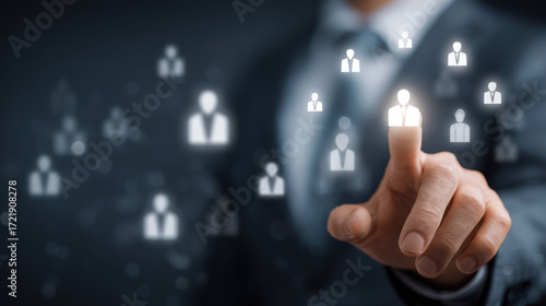Business professional interacting with digital network of people symbols in a corporate setting, representing connection and engagement