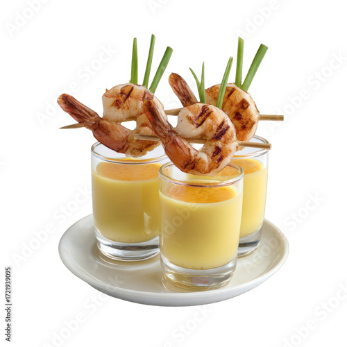 Four grilled shrimp appetizers served in shot glasses with yellow sauce and garnished with green chives, isolated on transparent background