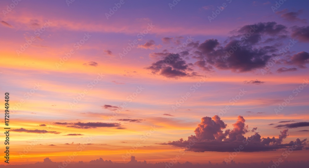 Naklejka premium A vibrant sunset sky with hues of orange pink and purple clouds