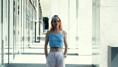 Free Download Portrait of a teenage girl with red hair standing near columns at the entrance to a business center - GFXLoad
