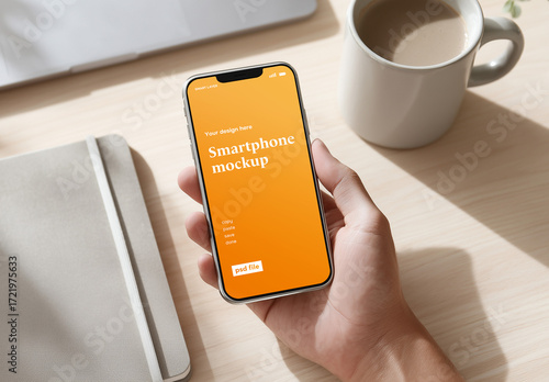 Smartphone screen mockup of hand holding mobile phone on office desk