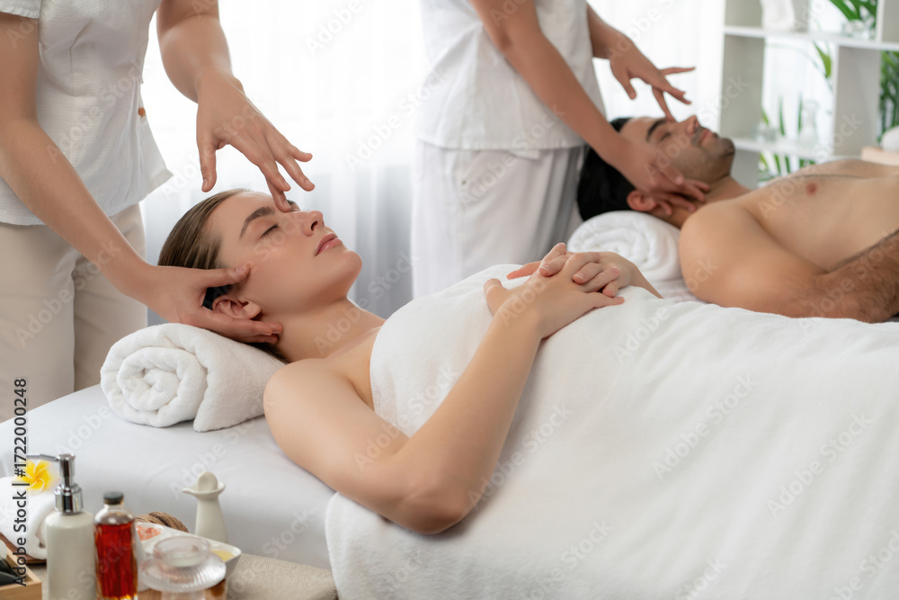 Obraz premium Caucasian couple enjoying relaxing anti-stress head massage and pampering facial beauty skin recreation leisure in dayspa modern light ambient at luxury resort or hotel spa salon. Quiescent