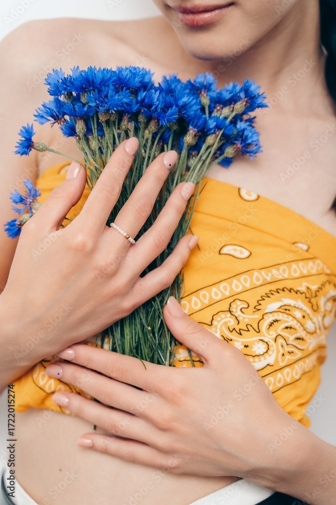 Fototapeta premium Hand with Pearl Ring Holding Blue Cornflowers
