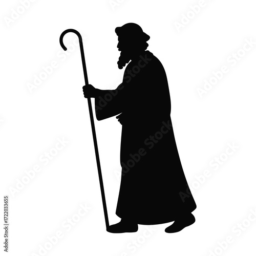 Black silhouette of elderly male shepherd in long robe holding crook, religious Christmas figure walking in profile view on white background