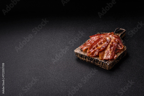 Fried pork bacon slices or strips as a breakfast ingredient. Fried bacon