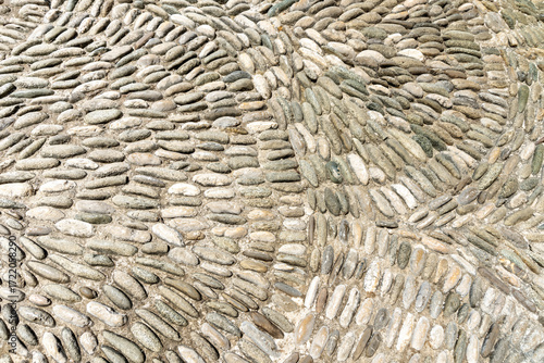 Curved cobblestone pavement in Mostar, Bosnia, showcasing traditional Balkan street design with textured stone arcs under soft summer light.