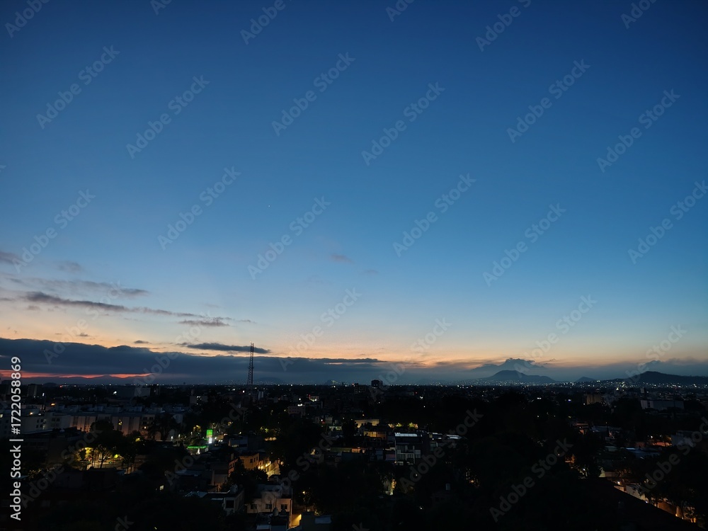 Naklejka premium La ciudad despierta lentamente, envuelta en tonos dorados y rosados que anuncian un nuevo comienzo. Cada rayo de sol se refleja en los edificios, convirtiendo lo cotidiano en un instante mágico.