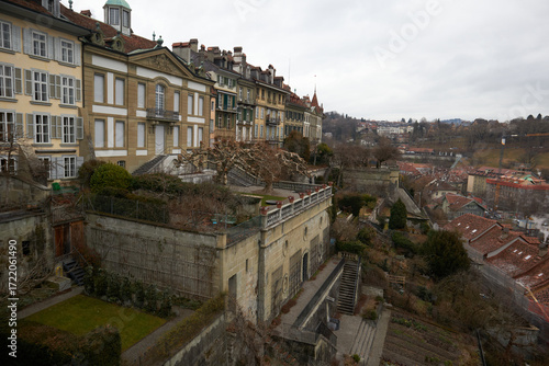 Canvastavla Ciudad en ladera con edificios históricos y muros de piedra, terrazas escalonadas y cielo gris sobre tejados antiguos