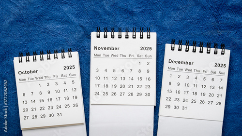 October, November and December 2025 - small spiral desktop calendars, time and business concept