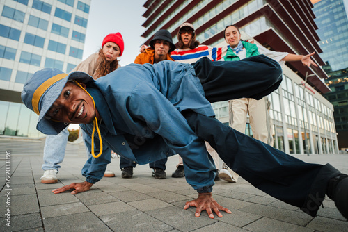 An energetic breakdancer showcases an impressive freeze move, captivating fellow dancers and onlookers with their incredible skills and enthusiasm for the art of dance, creating a vibrant atmosphere